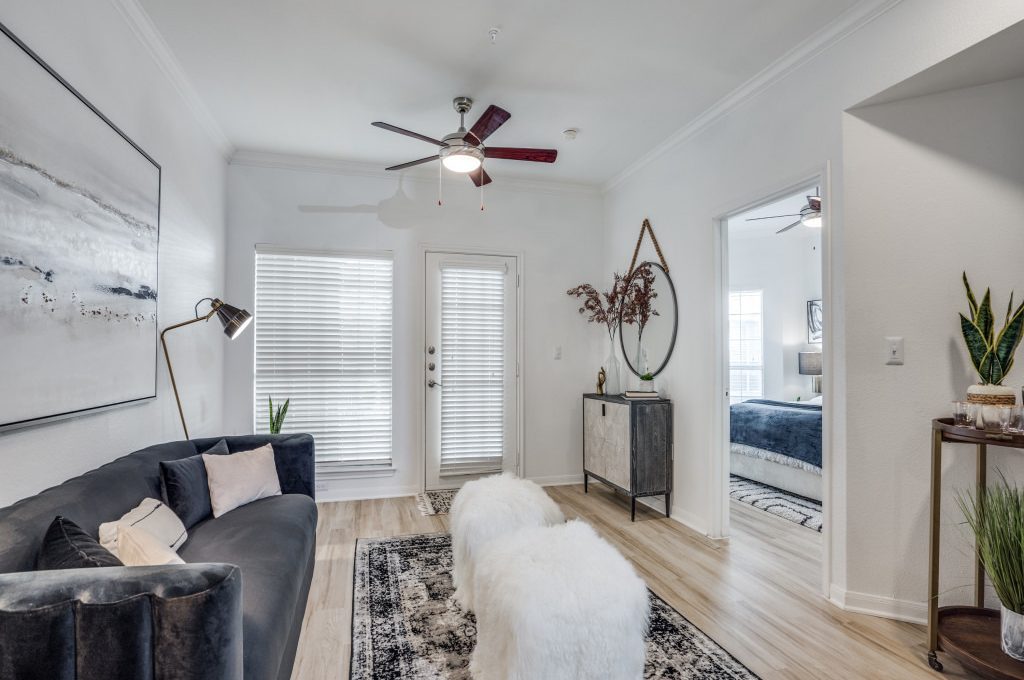 a living room with a rug and a ceiling fan at The NEO Midtown