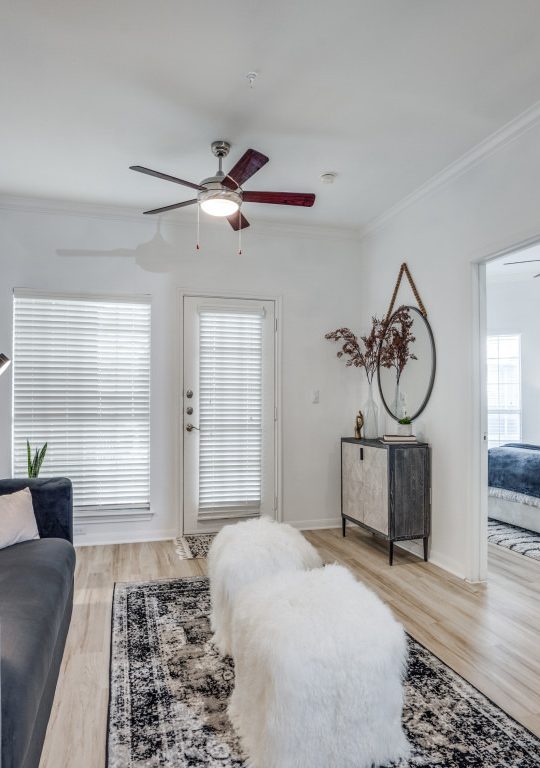 a living room with a rug and a ceiling fan at The NEO Midtown