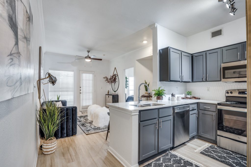 a kitchen with black appliances and gray cabinets at The NEO Midtown